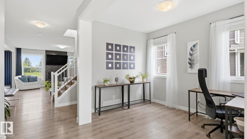 Bright, open-concept living space featuring wood-finish flooring throughout, recessed ceiling lighting, and abundant natural light from multiple windows - 63 Rosemount Boulevard, Beaumont, AB - Indoor Photo Showing Other Room
