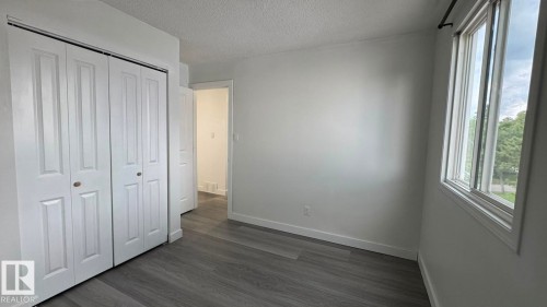 Wood-finish flooring, white walls, and a large window providing ample natural light - 41 Lancaster Terrace Nw, Edmonton, AB - Indoor Photo Showing Other Room
