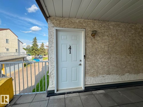 White paneled entry door with exterior wall sconce - 41 Lancaster Terrace Nw, Edmonton, AB - Outdoor With Exterior