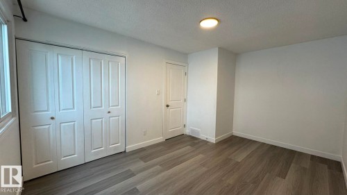 Wood-finish flooring, white walls, built-in bi-fold closet, recessed lighting, and a single window - 41 Lancaster Terrace Nw, Edmonton, AB - Indoor Photo Showing Other Room