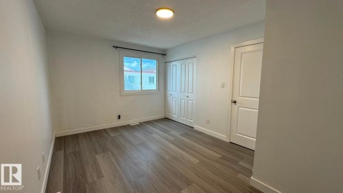 Recessed window with white trim, wood-finish flooring, and white interior doors - 41 Lancaster Terrace Nw, Edmonton, AB - Indoor Photo Showing Other Room