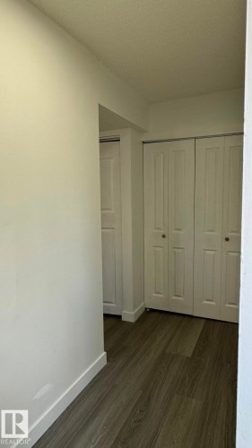 Wood-finish flooring with crisp white baseboards - 41 Lancaster Terrace Nw, Edmonton, AB - Indoor Photo Showing Other Room