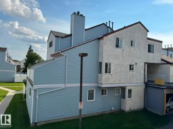 Multi-level exterior featuring light blue siding and textured stucco finishes - 