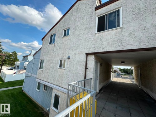 Stucco exterior with multiple windows, leading to an exterior covered walkway - 41 Lancaster Terrace Nw, Edmonton, AB - Outdoor With Exterior