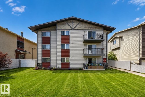 Multi-level building with individual balconies, light-colored siding, and a sloped roof - #4 4616 47 St, Leduc, AB - Outdoor