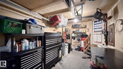 Utility space with concrete flooring, exposed ceiling beams, and a built-in wooden staircase - 