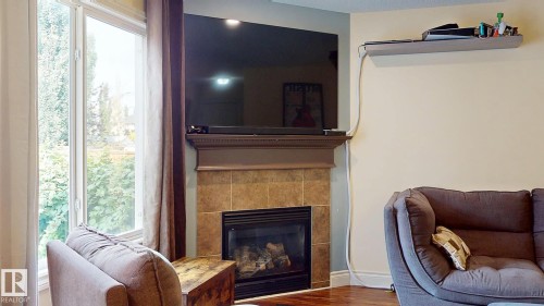 Fireplace with tiled surround and mantel - 107 Hartwick Loop, Spruce Grove, AB - Indoor Photo Showing Living Room With Fireplace
