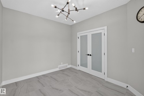 Room featuring a contemporary chandelier, light gray walls, and gray-toned tile flooring - 4703 41 Street, Beaumont, AB - Indoor Photo Showing Other Room