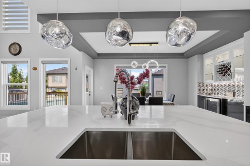 Spacious kitchen island featuring a dual-basin undermount sink and a polished chrome gooseneck faucet - 4703 41 Street, Beaumont, AB - Indoor Photo Showing Kitchen