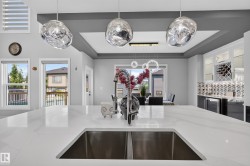 Spacious kitchen island featuring a dual-basin undermount sink and a polished chrome gooseneck faucet - 