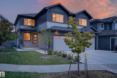 Contemporary exterior featuring mixed material siding, a dual-bay garage, concrete driveway, and a landscaped front yard with a walkway - 4703 41 Street, Beaumont, AB - Outdoor With Facade