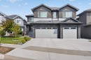 Modern two-story residence featuring a multi-textured facade with stone, horizontal siding, and vertical paneling - 4703 41 Street, Beaumont, AB  - Outdoor With Facade 