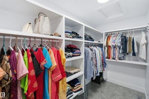 Custom-built closet system featuring extensive shelving, multiple hanging rods, and a neutral color palette - 4703 41 Street, Beaumont, AB - Indoor With Storage