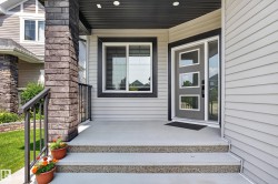 Front entry featuring a contemporary door with frosted glass inserts, a coordinating sidelight, and a large picture window - 