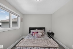 Bedroom featuring a large window with white trim, gray walls, and dark gray carpet flooring - 
