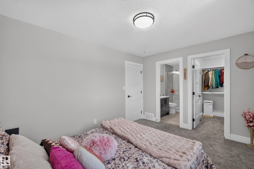 Neutral-toned bedroom featuring plush gray carpeting and a modern flush-mount ceiling light - 4703 41 Street, Beaumont, AB - Indoor Photo Showing Bedroom
