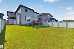 Spacious backyard featuring a large lawn area and light green privacy fencing - 