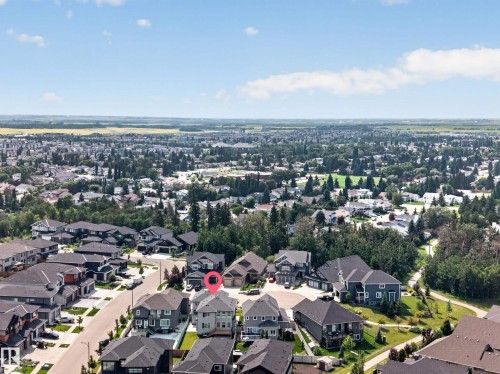 Aerial perspective showcasing a residential neighborhood with diverse housing styles, expansive green spaces, and tree-lined streets - 4703 41 Street, Beaumont, AB - Outdoor With View