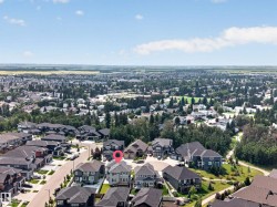 Aerial perspective showcasing a residential neighborhood with diverse housing styles, expansive green spaces, and tree-lined streets - 
