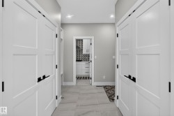 Hallway featuring light-toned tile flooring and recessed lighting - 