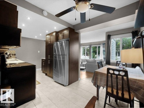 Kitchen with dark wood cabinetry, stainless steel refrigerator, and recessed lighting - 34 Amberly Court Nw, Edmonton, AB - Indoor