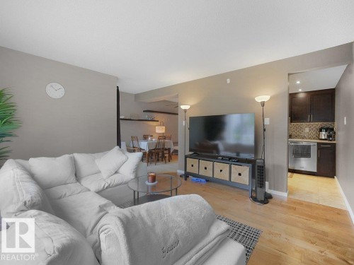 Wood-finish flooring throughout the living space - 34 Amberly Court Nw, Edmonton, AB - Indoor Photo Showing Living Room