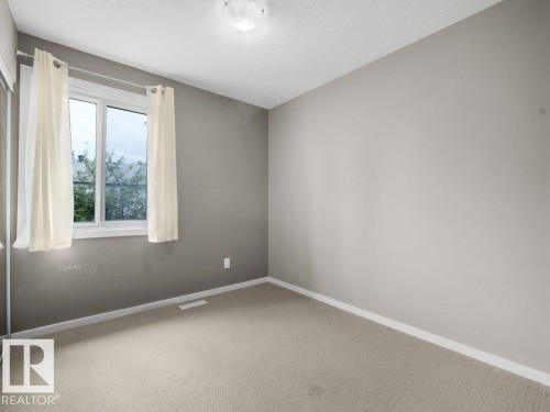 Carpeted flooring, contemporary wall color, and a window with a fixed-pane over a casement window - 34 Amberly Court Nw, Edmonton, AB - Indoor Photo Showing Other Room