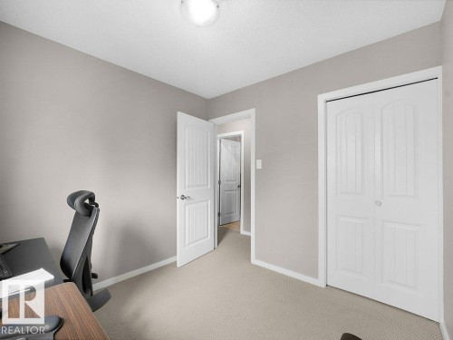 Neutral wall paint, plush carpeting, white trim, overhead flush-mount lighting, and bi-fold closet doors - 34 Amberly Court Nw, Edmonton, AB - Indoor Photo Showing Office