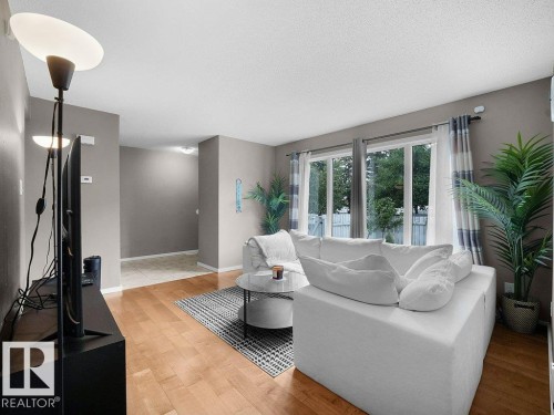 Hardwood-finish flooring, large windows, and neutral wall tones - 34 Amberly Court Nw, Edmonton, AB - Indoor Photo Showing Living Room