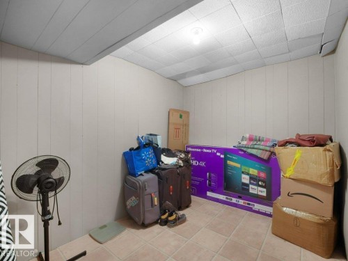Tile flooring, paneled walls, and a drop ceiling - 34 Amberly Court Nw, Edmonton, AB - Indoor Photo Showing Other Room