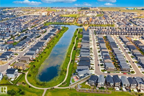 Canal-front property with direct access to a paved walking path, surrounded by a residential community with mature landscaping - 5493 Kootook Road Sw, Edmonton, AB - Outdoor With Body Of Water With View