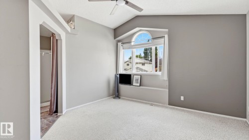 Carpeted room featuring a ceiling fan, vaulted ceiling, and an arched window with an integrated window seat - 4105 36A Avenue Nw, Edmonton, AB - Indoor Photo Showing Other Room