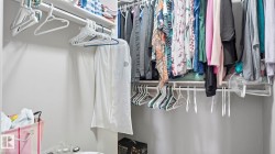 Closet featuring white shelving, a continuous clothes rod, and light gray wall paint - 