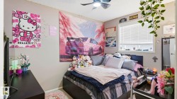 Bedroom featuring a ceiling fan with light fixture, window with blinds, and light-colored walls - 