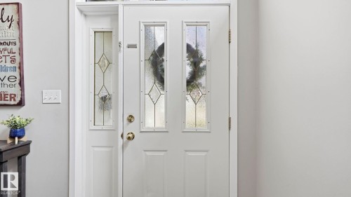 White entry door with decorative glass inserts and a sidelight with matching glasswork - 4105 36A Avenue Nw, Edmonton, AB - Indoor Photo Showing Other Room