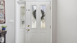 White entry door with decorative glass inserts and a sidelight with matching glasswork - 