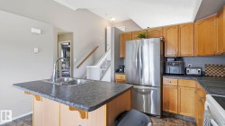 Kitchen featuring a double basin sink, stainless steel refrigerator, and wood-finish cabinetry - 