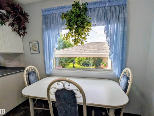 White upper cabinetry, dark countertop, and a window providing natural illumination - 6014 50 Street, Vegreville, AB - Indoor Photo Showing Dining Room
