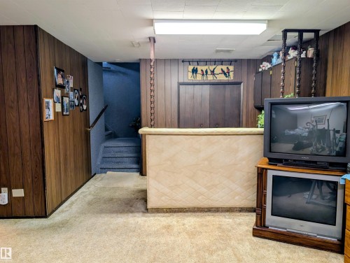 Carpeted flooring, wood paneling, built-in bar, recessed lighting, and carpeted stairs - 6014 50 Street, Vegreville, AB - Indoor