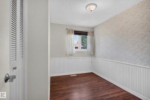 Wood-finish flooring, white wainscoting, and a ceiling-mounted light fixture - 2011 151 Avenue Nw, Edmonton, AB - Indoor Photo Showing Other Room