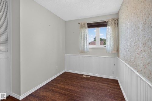 Wood-finish flooring, white beadboard wainscoting, and a white framed window - 2011 151 Avenue Nw, Edmonton, AB - Indoor Photo Showing Other Room
