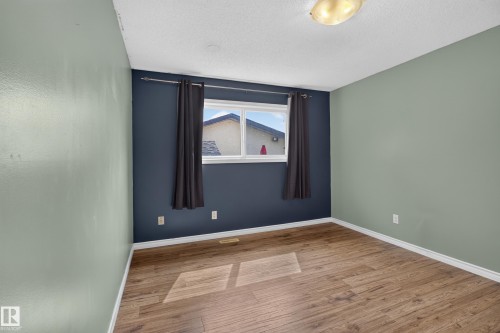 Wood-finish flooring with white trim - 2011 151 Avenue Nw, Edmonton, AB - Indoor Photo Showing Other Room