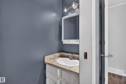Vanity with an integrated sink, patterned countertop, and chrome faucet - 2011 151 Avenue Nw, Edmonton, AB - Indoor Photo Showing Bathroom