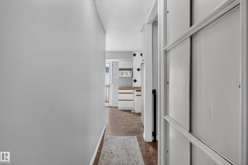 Hallway with wood-finish flooring and light gray walls - 2011 151 Avenue Nw, Edmonton, AB - Indoor Photo Showing Other Room