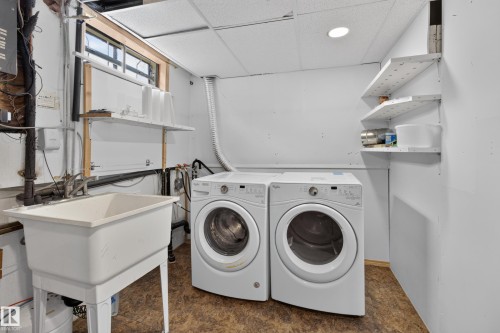 Laundry area featuring a utility sink, a window, and wall-mounted shelving - 2011 151 Avenue Nw, Edmonton, AB - Indoor Photo Showing Laundry Room