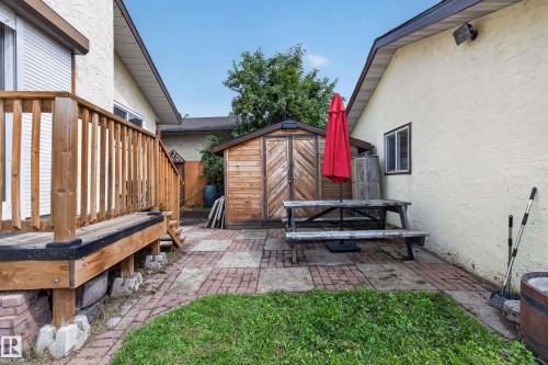 Wood-finish deck with railing, brick paver patio, and a wood-finish storage shed - 2011 151 Avenue Nw, Edmonton, AB - Outdoor With Exterior
