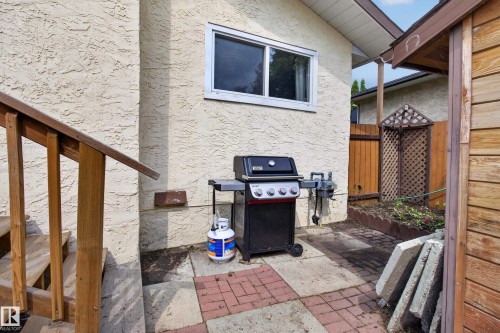 Covered patio with built-in gas grill, brick pavement, and access to the main residence - 2011 151 Avenue Nw, Edmonton, AB - Outdoor With Exterior