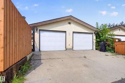 Two-car attached garage with white panel doors and exterior lighting fixtures - 2011 151 Avenue Nw, Edmonton, AB - Outdoor With Exterior