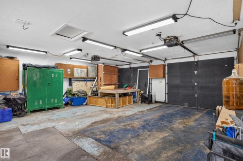 Attached garage featuring a white ceiling, fluorescent lighting, and a single garage door - 2011 151 Avenue Nw, Edmonton, AB - Indoor Photo Showing Garage