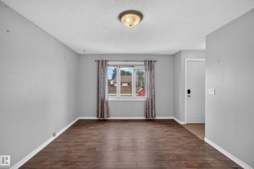 Wood-finish flooring, light gray wall tones, ceiling-mounted light fixture, white trim, and a white paneled door - 2011 151 Avenue Nw, Edmonton, AB - Indoor Photo Showing Other Room
